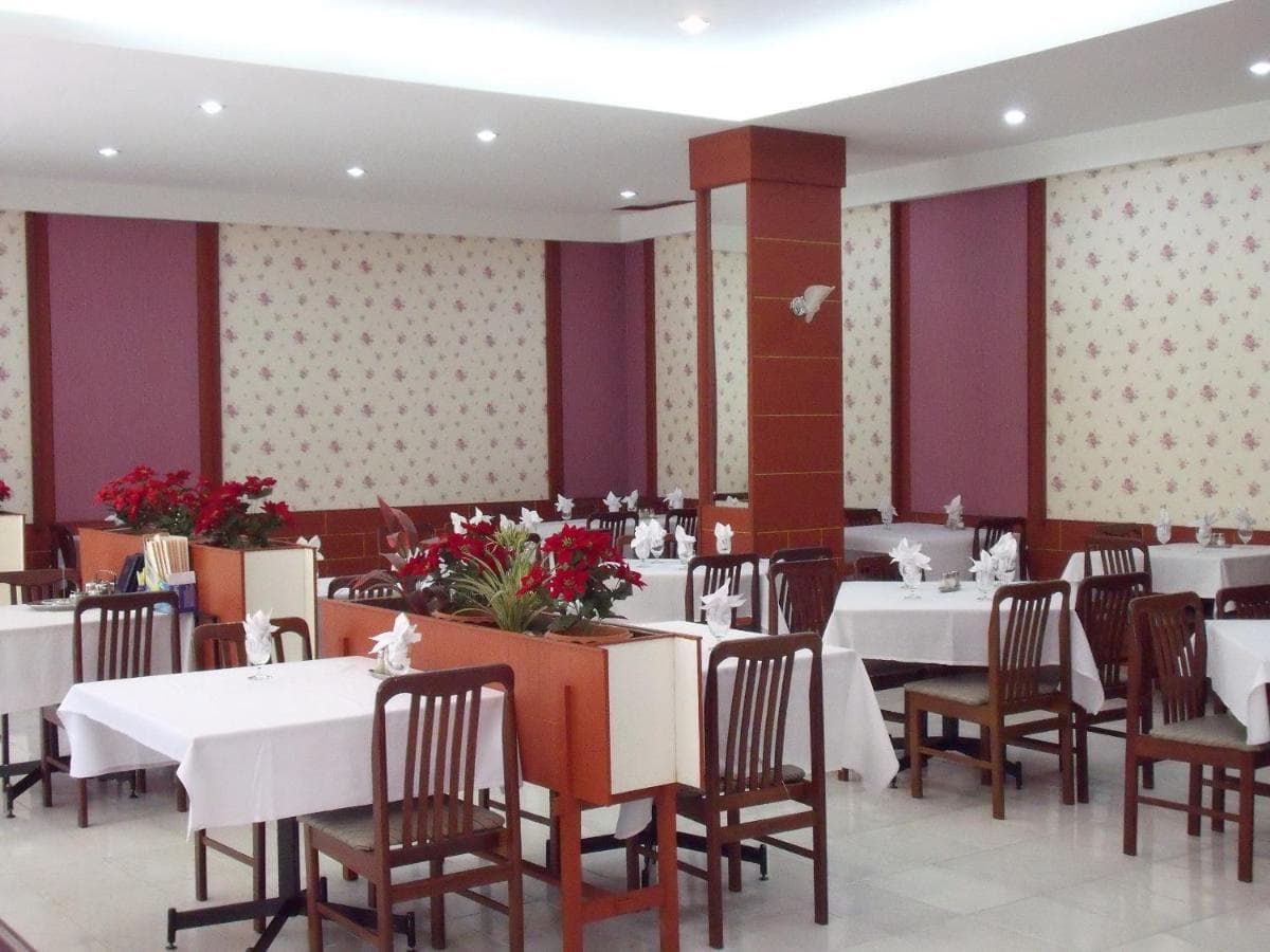 The hotel restaurant, with tables under white cloths and a floral centrepiece.
