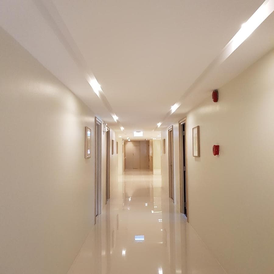 A guest room corridor lit by recessed ceiling lights.