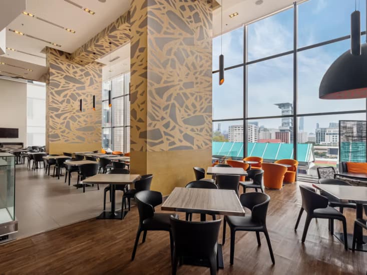 The breakfast room, with tables beside windows onto the city.