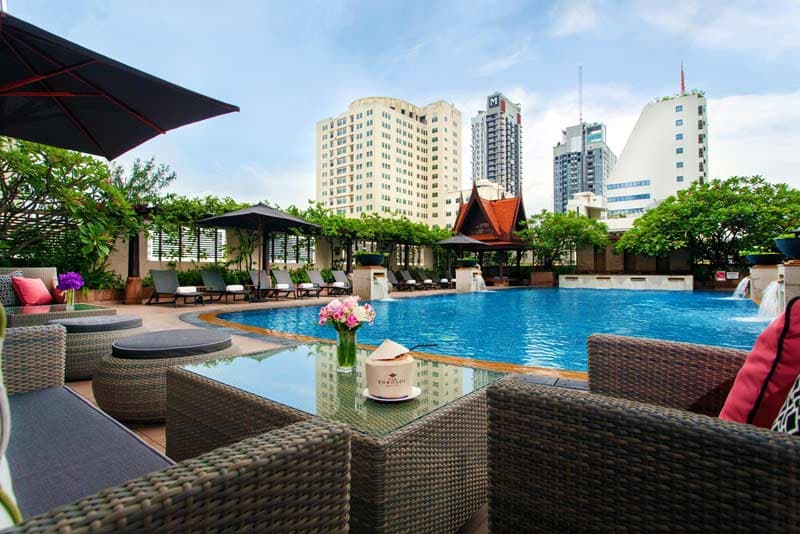 The outdoor pool, with loungers, parasols and a Thai pavilion at the far end.