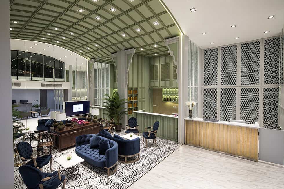 The lobby, with a green vaulted ceiling, patterned floor and reception desk.