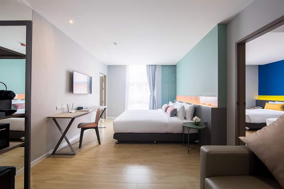 A connecting room, with a bed and desk and a doorway through to a second room.